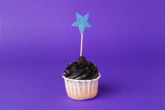 Beautiful cupcake against saturated dark purple background