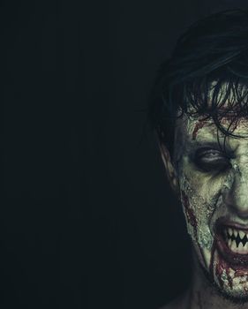 Half portrait of hungry zombie man with copy-space at left image, Halloween makeup