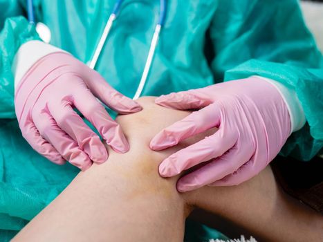 A doctor wearing medical gloves examines the bruise on the inside of the patient