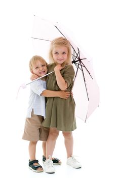 Brother and sister, girl and boy hid from the rain under an umbrella. The concept of a happy childhood, the vagaries of weather