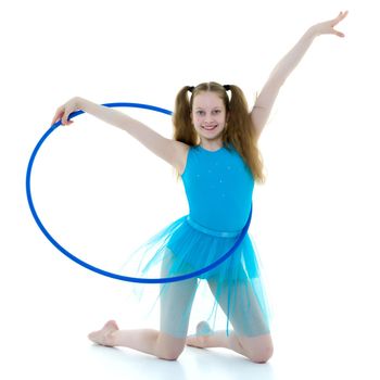 Beautiful girl gymnast performs gymnastic exercise in a photo studio on a black background. The concept of sports, a healthy lifestyle