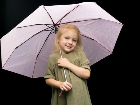 A nice little girl hid under an umbrella. The concept of a happy childhood, outdoor recreation, protection from bad weather. Isolated