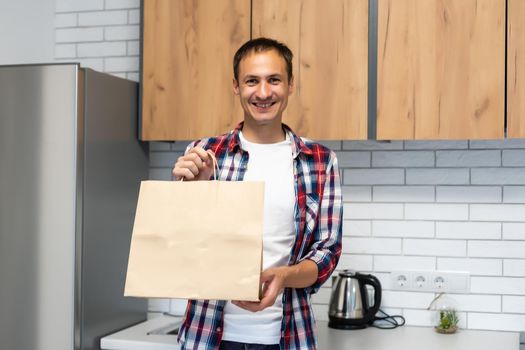 delivery, mail and people concept - happy man delivering food in disposable paper bag to customer home