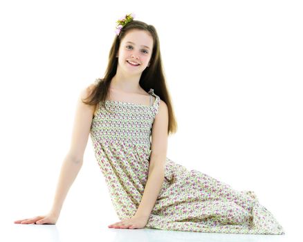 Teen girl teenager sitting on the floor in the studio. The concept of style and fashion. Isolated on white background.