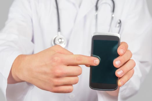 Man doctor is pointing on mobile phone, space for text