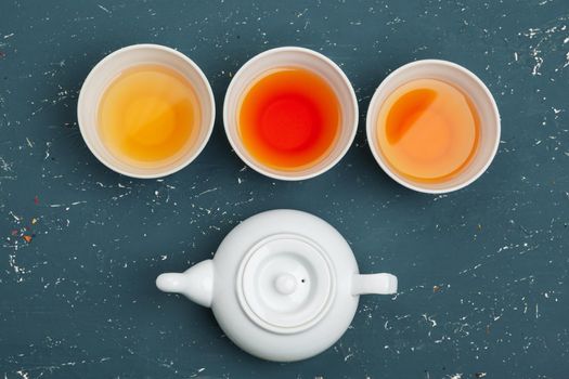 Collection of different teas in cups with tea leaves