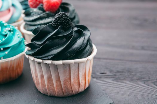 Set of different delicious cupcakes on dark