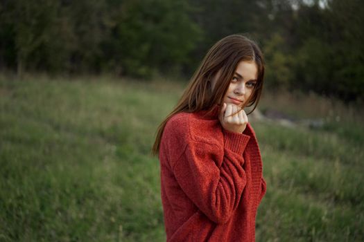 woman outdoors in a red sweater cool nature. High quality photo