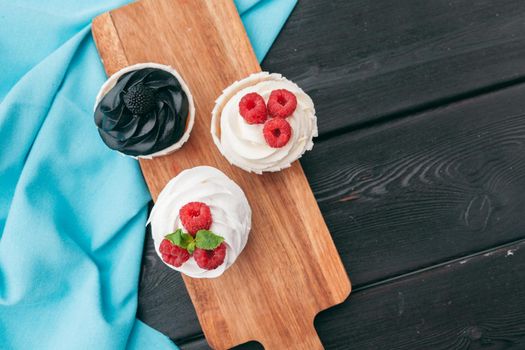 Close up of some decadent gourmet cupcakes frosted with a variety of frosting flavors