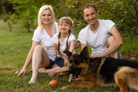 Portrait of an extended family with their pet dog sitting at the park