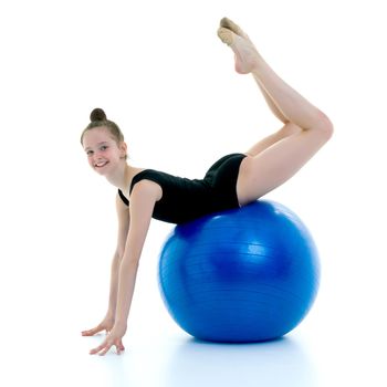 Beautiful little girl doing exercises on a big ball for fitness. The concept of sport and a healthy lifestyle. Isolated on white background.