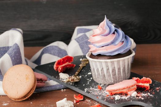 Delicious raspberry and caramel cupcakes on dark background