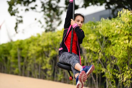 The little girl on the bungee jumping for kids outdoor.