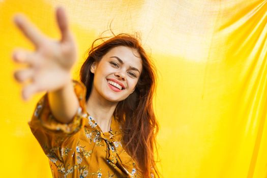 cheerful woman gesturing with her hands yellow background. High quality photo