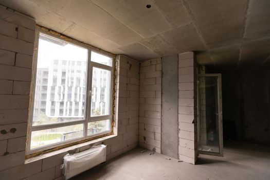 Small apartment without repair in a new building. A room in an unfinished house. Walls of foam block and concrete floor in a tiny apartment.