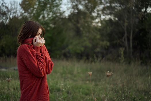 woman outdoors in a red sweater cool nature. High quality photo