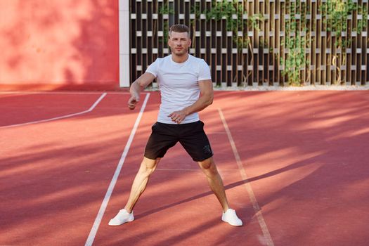 man in white t-shirt on the sports ground workout motivation. High quality photo