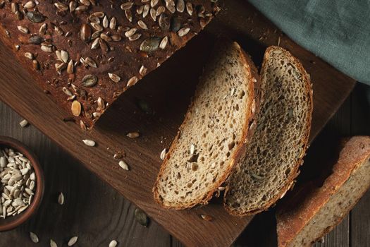 Sliced Homemade Whole Grain Bread with Seeds on a Cutting Board.