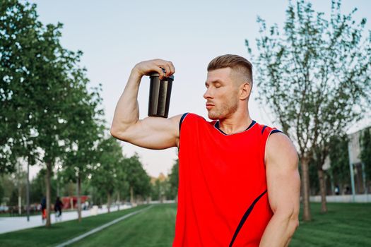 sporty man in the park outdoors glass with drink. High quality photo