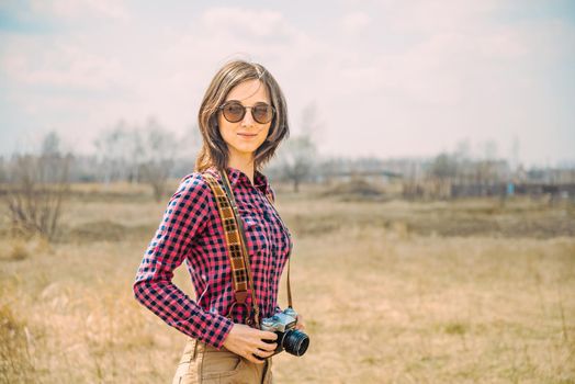 Hipster happy girl with vintage photo camera outdoor