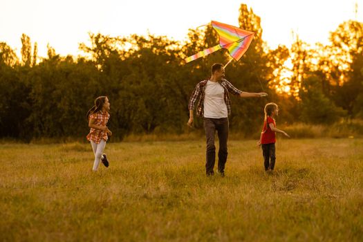 Dad with his little daughter let a kite in a field