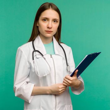 Happy smiling young female doctor with clipboard, isolated over background - image
