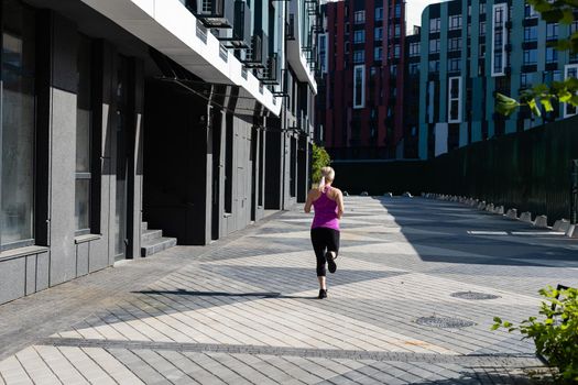 Fitness sport woman in fashion sportswear doing yoga fitness exercise in the street, outdoor sports, urban style