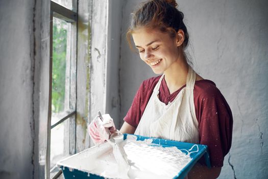 woman in apron painter repair painting window. High quality photo