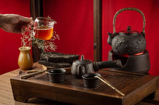 the tea table with instruments teapots cups pancake and tea Shen Puer