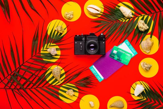 Flat lay traveler accessories with palm leaf, seashells, camera, pasport, money and air ticket . Top view travel or vacation concept. Summer background.