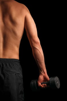 Unrecognizable muscular man exercise with dumbbell, rear view