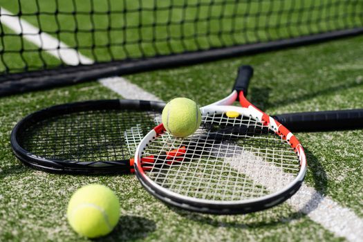 A tennis racket and new tennis ball on a freshly painted tennis court