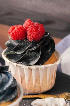 Tasty cupcakes on a dark wooden table