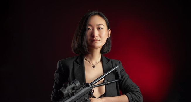 the asian woman in a jacket with an automatic rifle in her hands mafia fighter