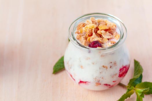 healthy products for breakfast, granola and fresh berries on white table