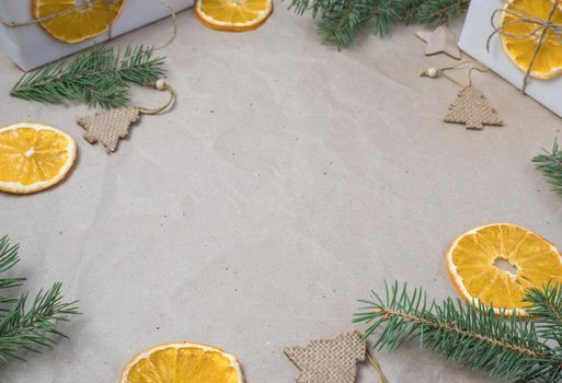 New Year's composition. Light beige parchment paper background with place for text, gift boxes, dry orange oranges, fir branches. Flat lay, top view. Nordic, hygge, cozy christmas concept