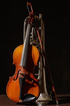 Broken trumpet and violin on the wooden floor.