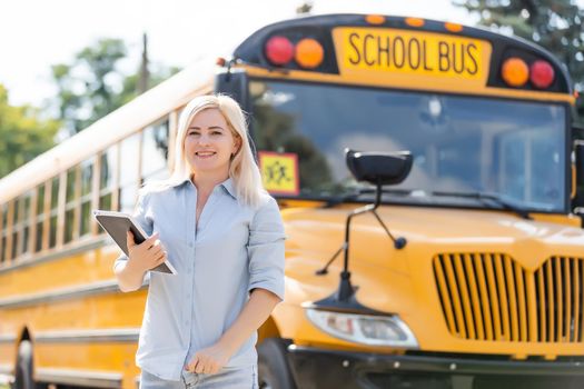 Teacher at school in front of the bus