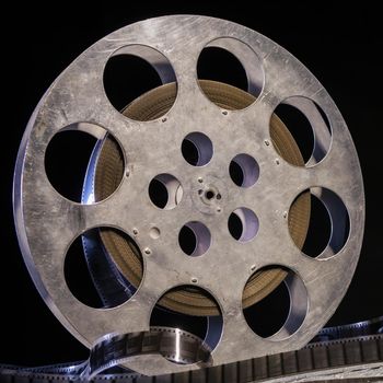 35 mm film reel with dramatic lighting on a dark background - image