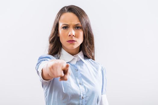 Image of angry businesswoman pointing on gray background.