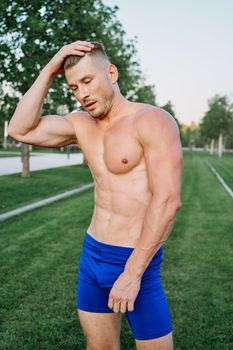 sporty muscled man with naked torso in a workout park. High quality photo