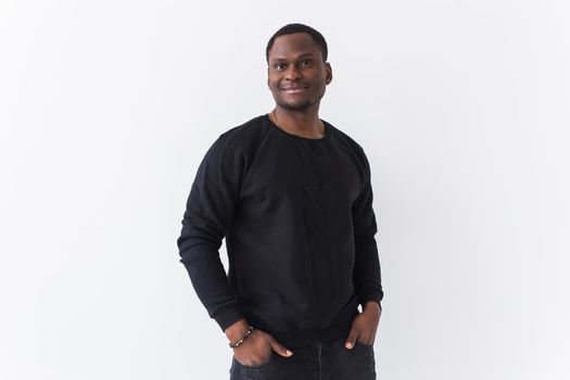 Studio shot of young handsome African man wearing hoodie against white background.