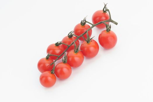 Ripe cherry tomatoes on a twig on a white background - image