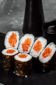 Simple maki with fresh salmon. Sushi on a gray background.