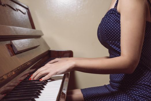 detail of woman hands playing the piano.