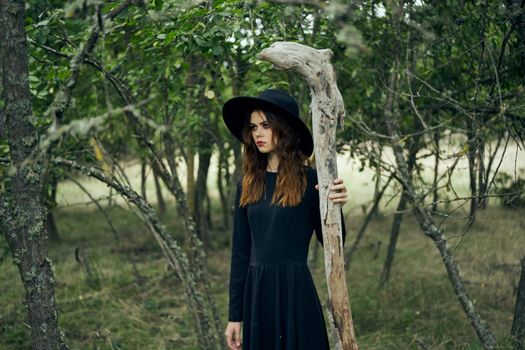 woman in witch costume in forest posing staff logic. High quality photo
