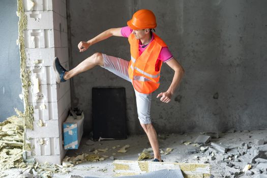 profession, construction and building - happy smiling worker or builder in helmet over room with working equipment at new home or apartment background