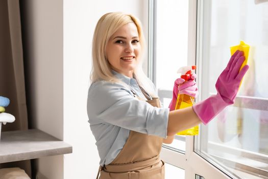 The woman washes a window in apartment