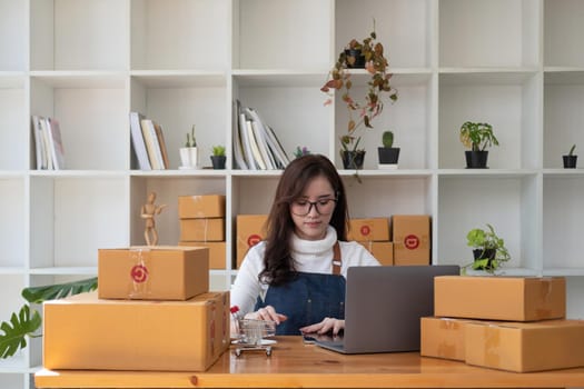 Starting Small business entrepreneur SME freelance,Portrait young woman working at home office, BOX,smartphone,laptop, online, marketing, packaging, delivery, SME, e-commerce concept