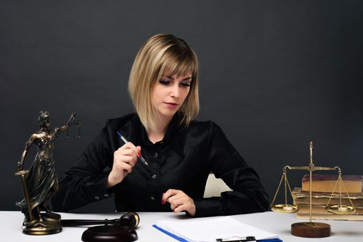 A young fair woman judge works in her office. - image